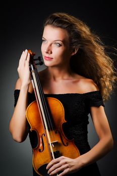 Woman with violin in dark room