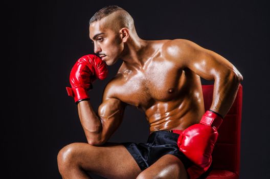 Boxer with red gloves in dark room