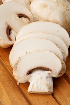 Full Body and Slices of Сhampignon closeup on Wooden background