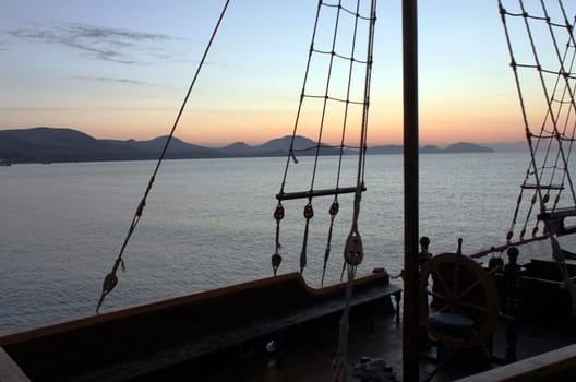 rigging of boat over landscape before sunrise