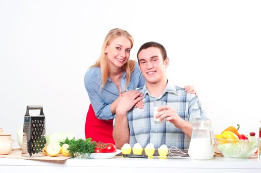 wife embraces the husband, he holds a glass of milk