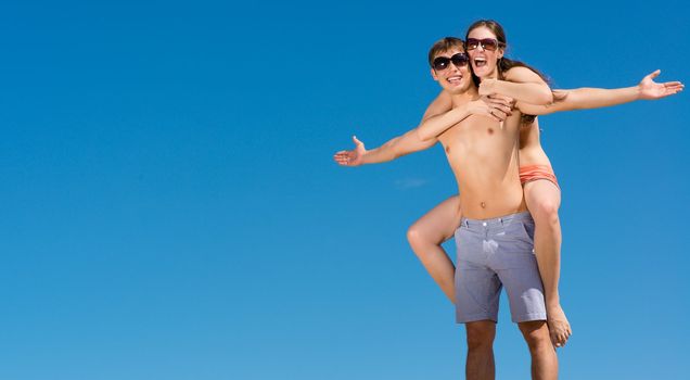 Young couple hugging on a background of blue sky, hold together honeymoon