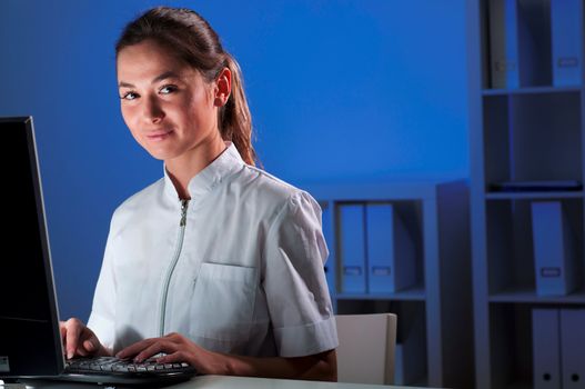 beautiful young woman doctor working at night in the office