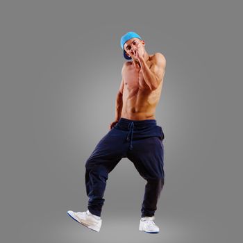 dancer of hip-hop on a gray background , motion