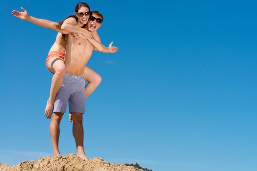 Young couple hugging on a background of blue sky, hold together honeymoon