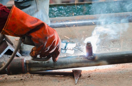 hand of worker welding steel pole