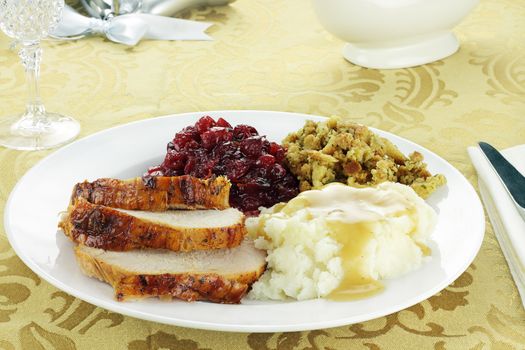 Thanksgiving turkey dinner with mashed potatoes and gravy, stuffing, and homemade cranberry sauce.