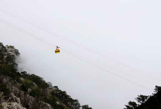 aerial ropeway cabin going to mountain in clouds