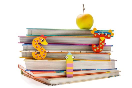 Stack of books with funny letters and a healthy snack