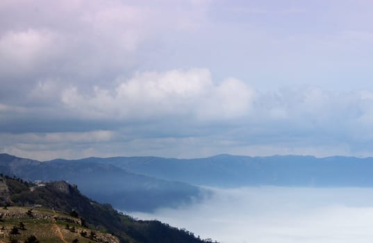 mountains between clouds