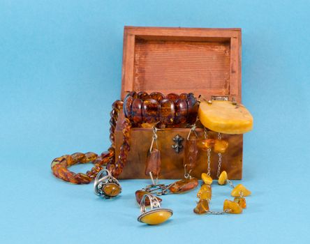 Amber apparel jewelry in retro wooden box on blue background