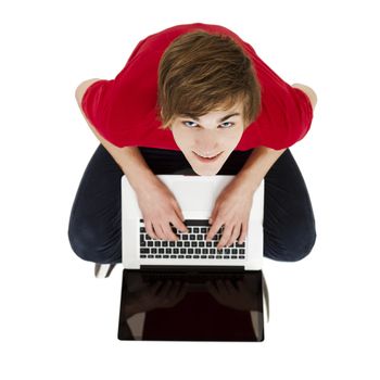 Top view of young man sitting in the floor and working with a laptop