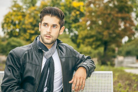 An image of a young man with a black leather jacket