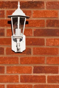 white classic lamp on a brick wall (copy-space available)