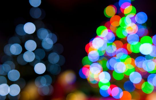 two blurred christmas tree lights on a black background