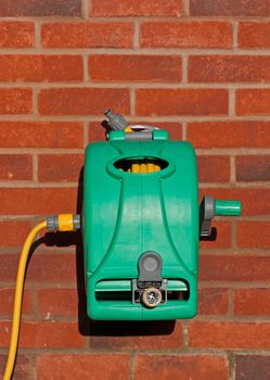 garden hose reel kit installed on a brick wall (copy-space available)