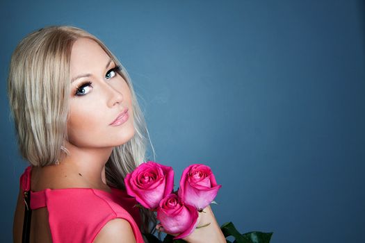 Blond girl holding three pink roses