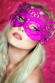 A close up portrait of a blonde with a pink mask 