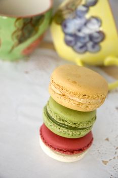 stack of colorful macarons with colorful cups background