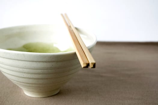 japanese bowl with chopstick on brown color background