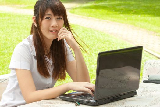 Asian young woman working with her notebook and smiling