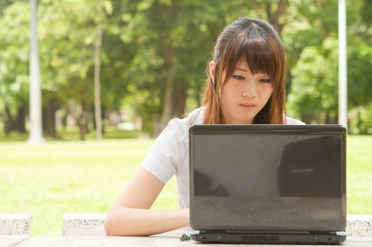 Young asian woman playing notebook