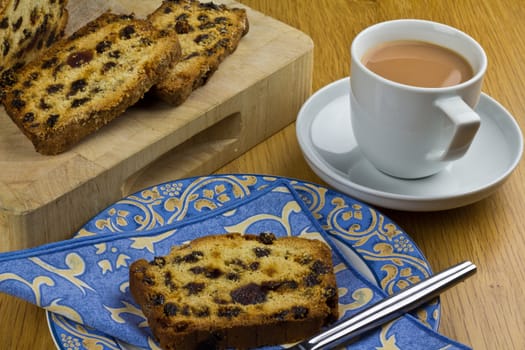 A cup of tea and a slice of fruit loaf cake