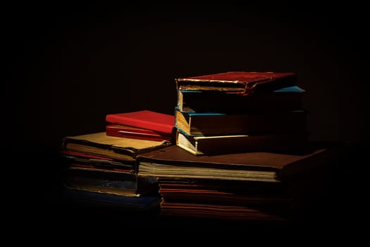 collection of old worn books on black