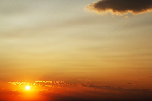 Bright orange sunset sky with cloud and space for text