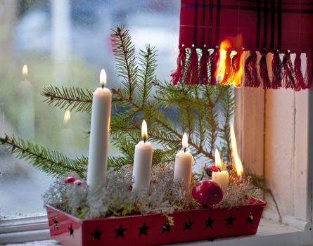 Burning candles in advent candle wreath setting fire on a curtain