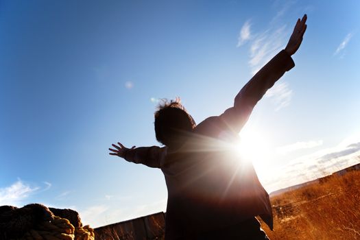 Silhouette of boy with open arms to the sky