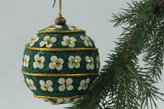 Hand crafted bulb hanging on Christmas tree branches, with white background
