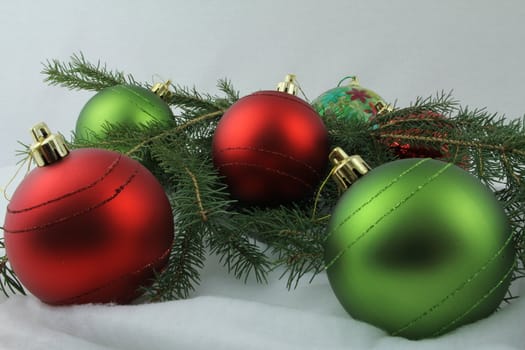 Red and green Christmas bulbs, with needles on white background
