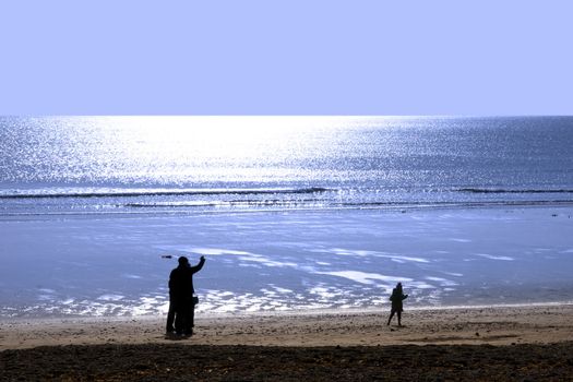 family strolling along the beach before sunset in Ballybunion county Kerry Ireland