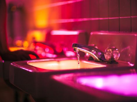 Bathrom taps lit in bright colors at a party