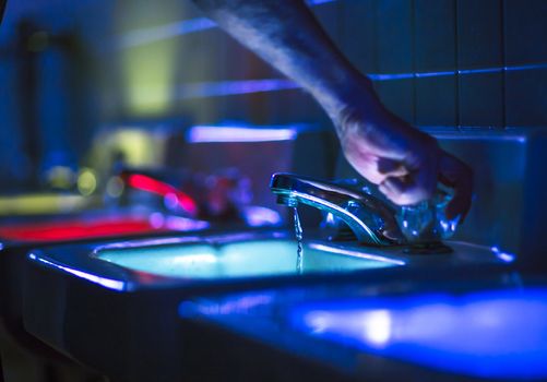 Bathrom taps lit in bright colors at a party