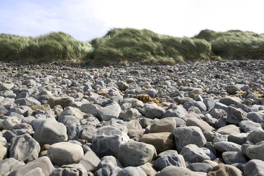 a rocky beach in Kerry on the west coast of Ireland with dunes in background