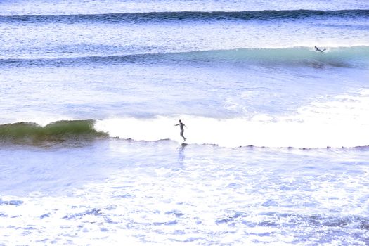 beautiful clean deep blue atlantic ocean with surfers catching the waves on Irelands coast