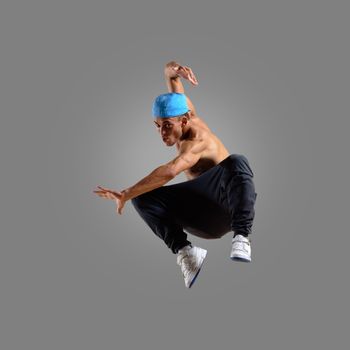 dancer jumping on a gray background, having a fun