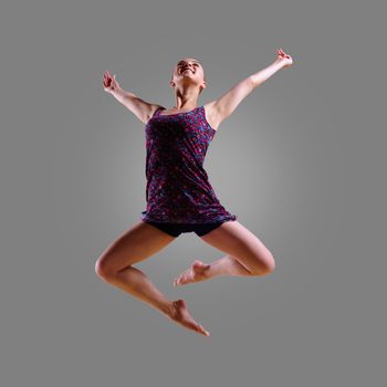 dancer jumping on a gray background, having a fun