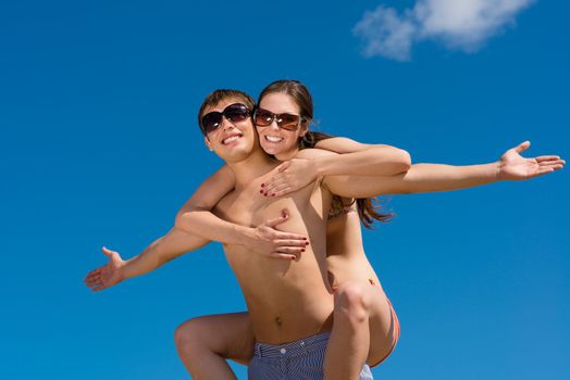 Young couple hugging on a background of blue sky, hold together honeymoon