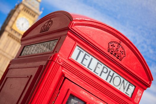 Main London symbols: red public telephone box and clock on Big Ben tower of Westminster Palace on cloudy sky background in Great Britain