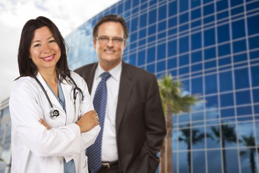 Attractive Hispanic Doctor or Nurse and Businessman in Front of Corporate Building.