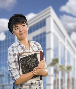 Attractive Mixed Race Female Student Holding Books in Front of Building.