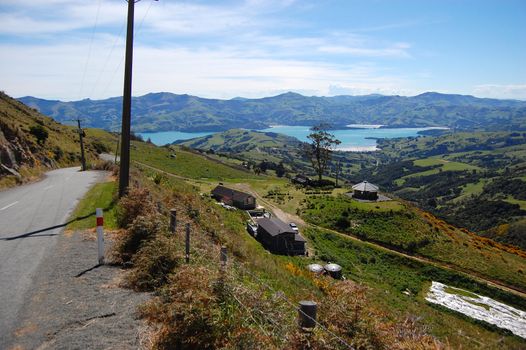 Road goes down to sea bay, near Akaroa, Banks Peninsula, New Zealand