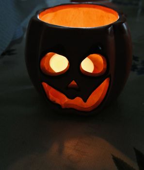 Jack-O-Lantern with lit candle inside in the darkness