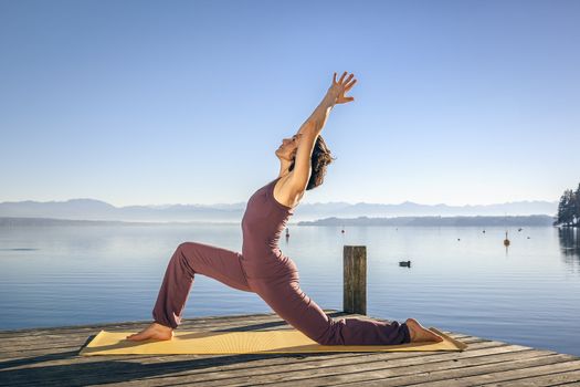 An image of a pretty woman doing yoga at the lake