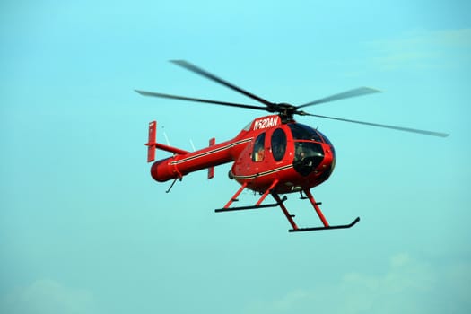 rotorless red helicopter hovering over an airfield