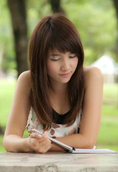Beautiful asian girl reading her text in notebook