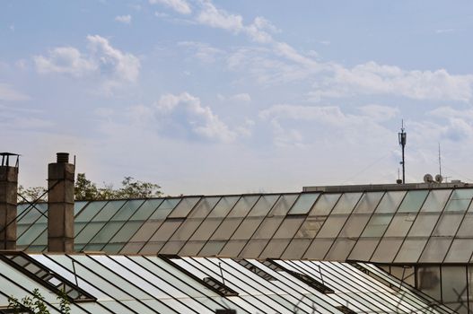 Greenhouse glass roof and cloudy sky. Abstract background.